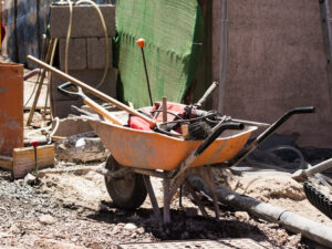 Carrinho de mão com ferramentas de construção em um canteiro de obras.